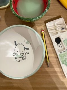 a bowl with a drawing on it next to other bowls