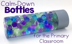 a tube filled with lots of different colored glass beads on top of a white surface