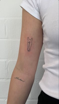 a woman's arm with a small horse head tattoo on the left side of her arm