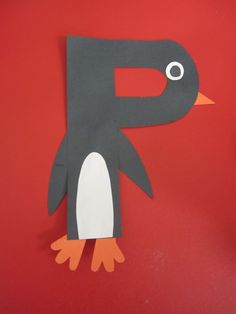 a penguin made out of construction paper on a red background with the letter p cut out