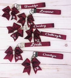 several red bows with name tags attached to them on a white wooden background, one for each girl and the other for her brother