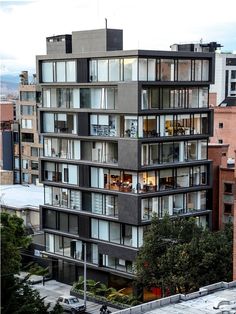 an apartment building with lots of windows and balconies on the top floor is shown