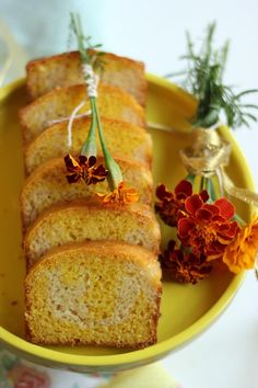 several slices of cake on a yellow plate with flowers in the bowl next to it