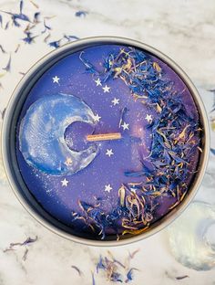 a blue cake with white stars on it in a metal pan, surrounded by confetti