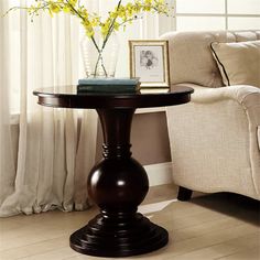 a living room scene with focus on the end table and flowers in front of the window