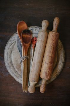 wooden utensils and spoons are sitting on a plate