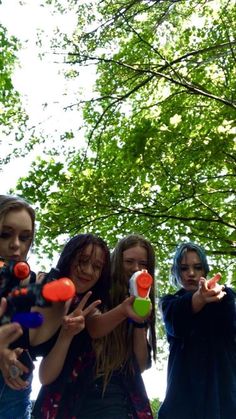 four girls are holding up toys in the air and pointing at them with their fingers