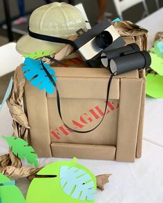 a cardboard box filled with construction equipment and paper cut outs on top of a table