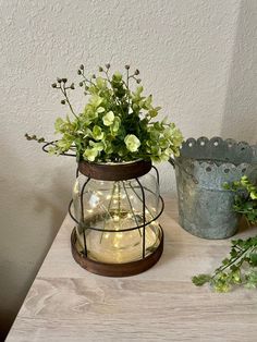 two vases filled with flowers sitting on top of a wooden table next to each other