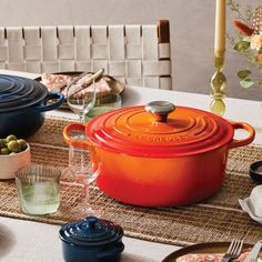 an orange casserole is sitting on a table with other dishes and utensils