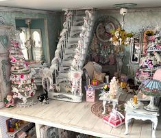 a doll house with furniture and accessories in it's display area, including a staircase leading up to the second floor