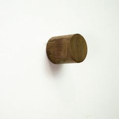 a close up of a wooden knob on a white wall