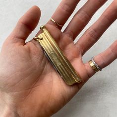 a person's hand holding an open gold ring