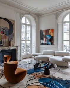 a living room filled with lots of furniture next to large windows and a fire place