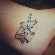 a small tattoo on the ankle of a woman's foot with an origami design