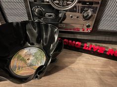 an old radio sitting on top of a wooden table next to a black hat and other items