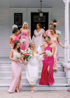 a group of bridesmaids standing on the steps of a house