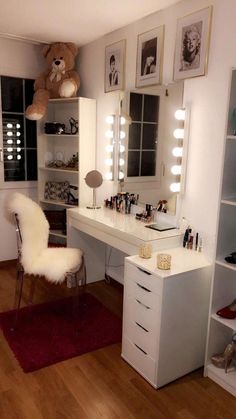 a white vanity with lighted lights and a teddy bear