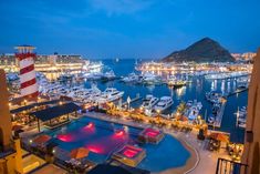 a marina filled with lots of boats and lights on top of the water at night