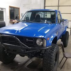 a blue pick up truck parked in a garage