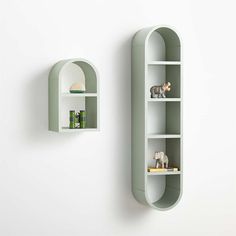 two green shelves are next to each other in the shape of an arch and one has a toy elephant on it