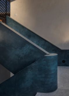 an empty room with blue walls and stairs