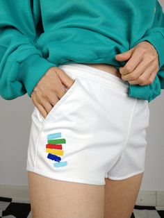 DESCRIPTION The White Tacchini is a 90s vintage gem from Sergio Tacchini. This white tennis shorts has a colorful embroidery and the Sergio Tacchini logo in the front. Labaled as a size 40, estimated to fit like XS-S. This shorts has light stretch and is made in Italy. CONDITION The vintage shorts is in great condition SIZING This vintage shorts is estimated as a size XS-S and labeled as size 40 > please check measurements below Measurements: Waist: 36cm Front till crotch seam: 20cm Hips: 47cm Back: 25cm Model wears size XS/S and is 1m65  MATERIAL 100% polyester BRAND Sergio Tacchini made in Italy 90s rare piece WITH LOVE  All vintage fashion for women are washed and shipped from Berlin with a lot of love Your favourite online vintage clothing shop  The Vintage Takeaway Retro White Short Bottoms, Retro White Shorts For Spring, White Retro Shorts For Spring, White Sporty Tennis Athletic Shorts, White Cotton Cheerleading Bottoms, White Cotton Bottoms For Cheerleading, Sporty White Athletic Shorts For Tennis, White Shorts For Cheerleading, Casual White Athletic Shorts For Cheerleading