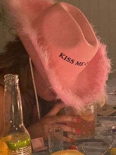 a woman wearing a pink hat sitting at a table with lemons and other food