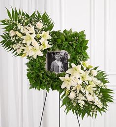 a memorial wreath with white flowers and greenery