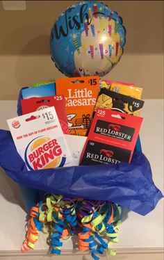 a birthday gift basket with balloons, books and other items for a child's first birthday