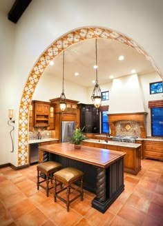 a large kitchen with an archway leading into the dining room