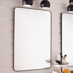 two mirrors are hanging on the wall above a sink