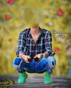 a man sitting on the ground holding a game controller in his hands with butterflies flying around him