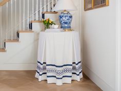 a blue and white vase sitting on top of a table next to a stair case