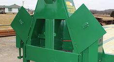 a large green machine sitting in the middle of a field