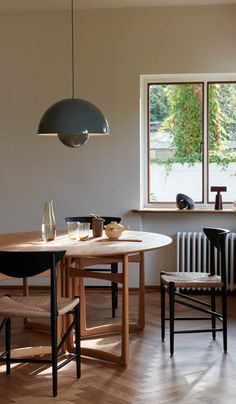 a table and chairs in a room with a window on the wall above it, next to a radiator