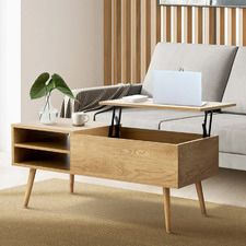 a living room with a couch, coffee table and laptop on top of the table