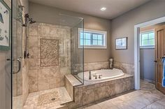 a bathroom with a walk in shower next to a bath tub