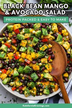 black bean mango and avocado salad in a bowl with a wooden spoon