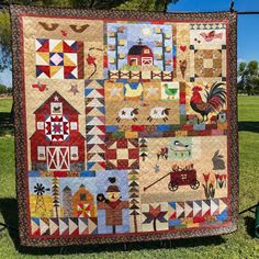 a quilt hanging on the side of a fence in front of some trees and grass