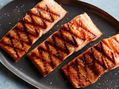 four pieces of grilled meat on a black plate