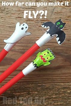 three red and white plastic chopsticks with cartoon characters on them, one has a black cat