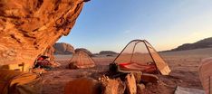 two tents set up in the desert next to rocks