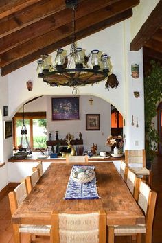 a dining room table with chairs and a chandelier hanging from it's ceiling