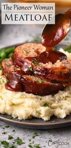 a plate with mashed potatoes and meat on it that is being drizzled with sauce