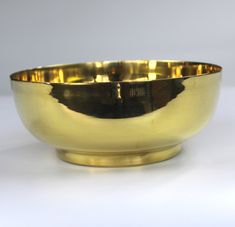 a golden bowl sitting on top of a white table