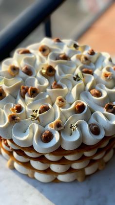 a cake with white frosting and nuts on top