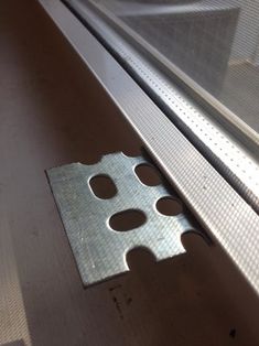 a metal object sitting on top of a counter next to a glass door with holes in it