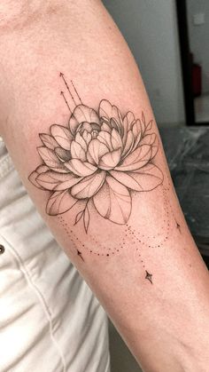 a woman's arm with a flower tattoo on it