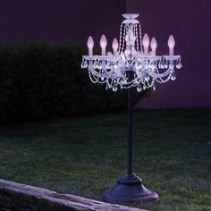 a chandelier is lit up outside in the dark